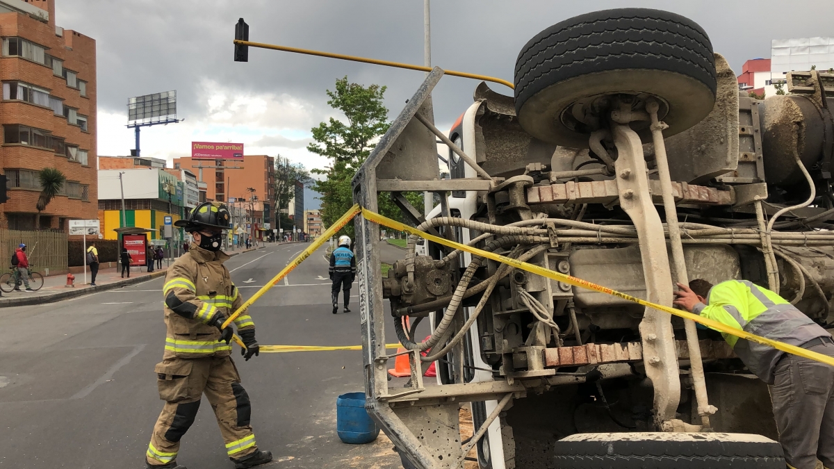 Bombero al lado de vehículo volteado